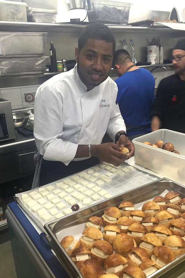 Alex Clavijo montando sus panes de yuca con queso fresco y pico de gallo de tomate de árbol