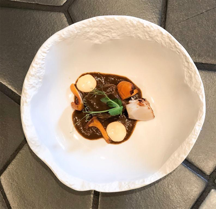 Bombón de chocolate, carrillera al vino tinto, acompañados de manzana y castaña